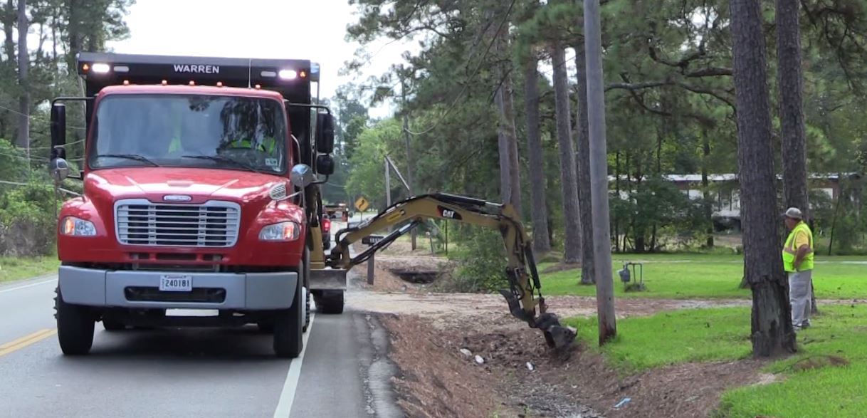 Public Works employees digging out ditches to improve drainage